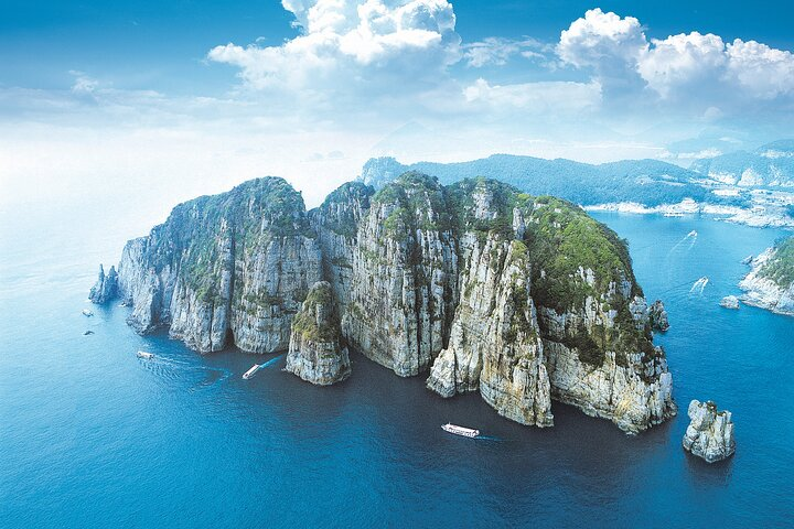 Discover majestic cliffs rising from the clear blue sea dotted with boats. Experience nature’s charm at Hallyeohaesang National Park where countless islands await your exploration.
